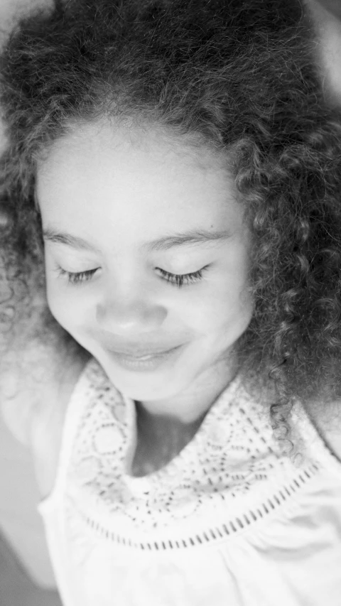 a black and white photo of a little girl brushing her hair, a black and white photo, light skinned african young girl, closeup headshot, toy commercial photo, sunlight beaming down