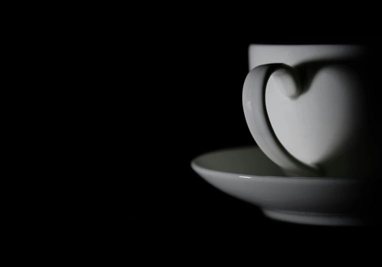 a white cup sitting on top of a saucer, inspired by Robert Mapplethorpe, flickr, heart, dark monochrome, colour photograph, night!