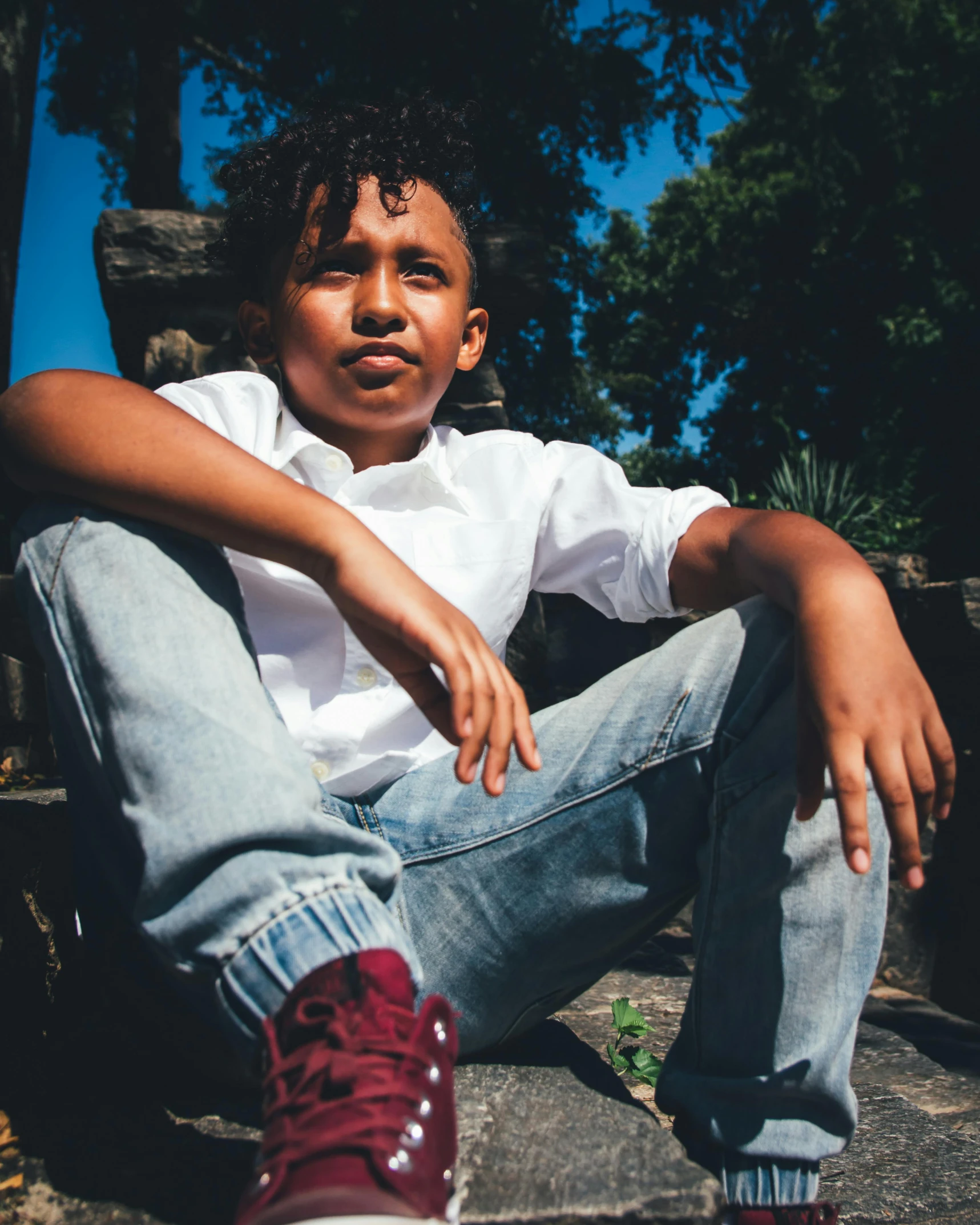 a young man sitting on the steps of a building, an album cover, pexels contest winner, kids, non-binary, brown skinned, 15081959 21121991 01012000 4k