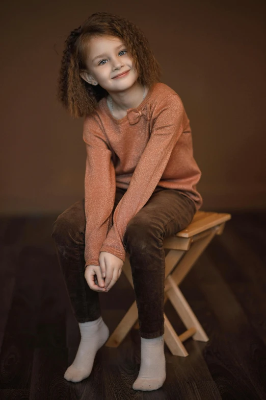 a little girl sitting on top of a wooden chair, by Henriette Grindat, trending on pexels, renaissance, brown sweater, portrait of teen girl, official store photo, brown pants
