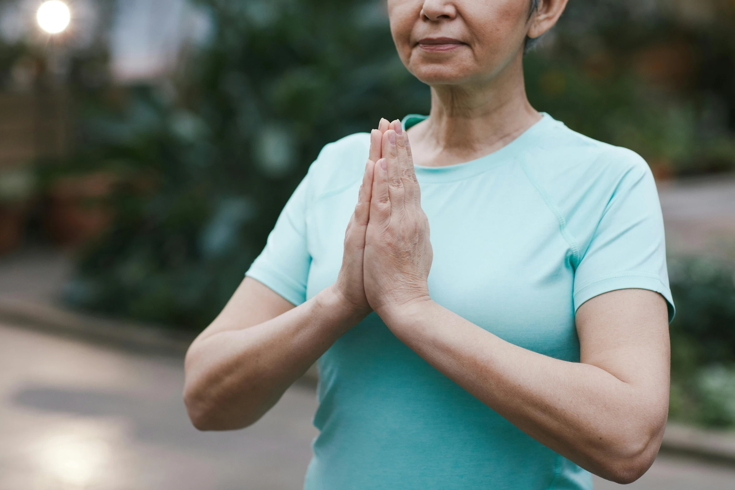 a woman in a blue shirt doing a yoga pose, pexels contest winner, hurufiyya, wrinkles and muscle tissues, avatar image, prayer hands, south east asian with long