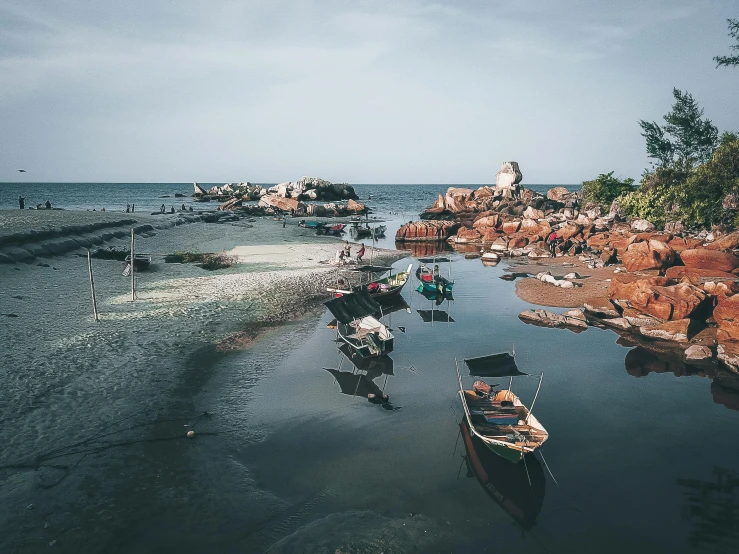 a group of boats floating on top of a body of water, by Daniel Lieske, unsplash contest winner, vietnam, rocky shore, inlets, thumbnail