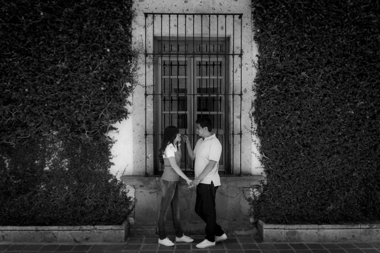 a couple standing next to each other in front of a building, a black and white photo, inspired by Luis Paret y Alcazar, with ivy, los angeles 2 0 1 5, holding hands, 15081959 21121991 01012000 4k