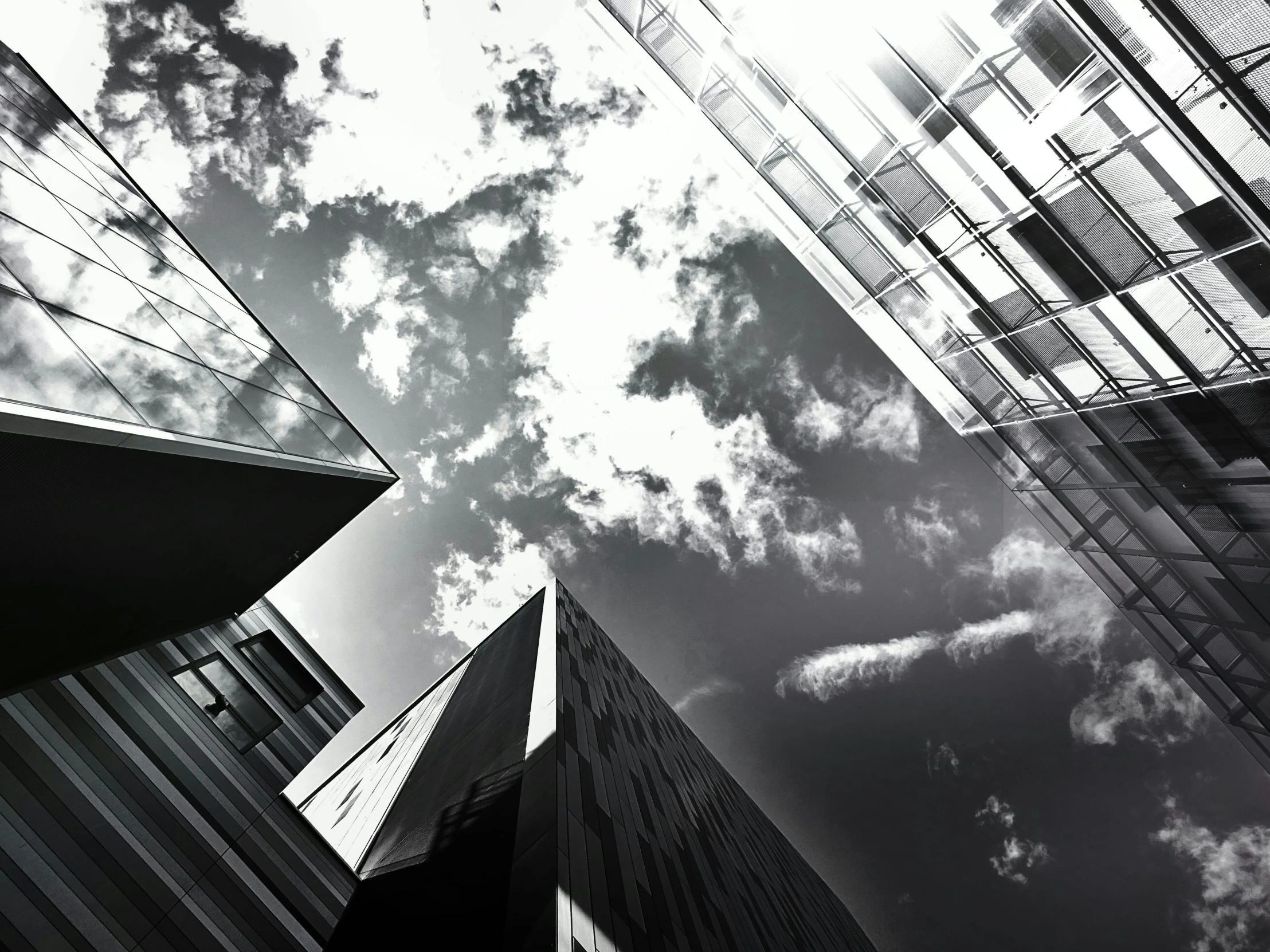 a black and white photo of tall buildings, a black and white photo, unsplash, minimalism, dramatic skies, morphosis, solarised, various angles