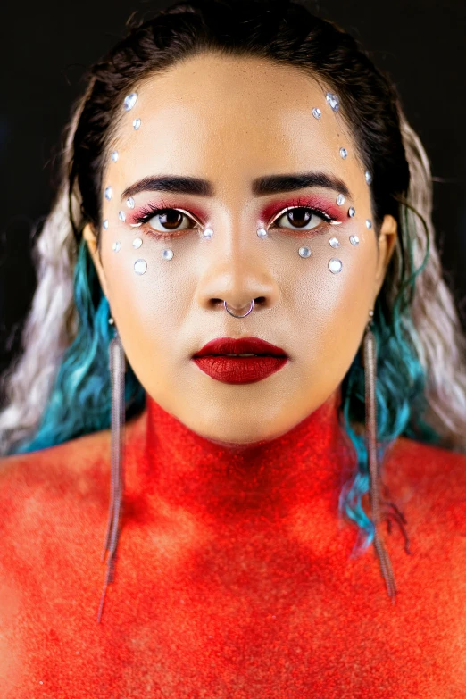 a woman with blue hair and glitter on her face, an album cover, inspired by Luma Rouge, trending on pexels, wearing a red outfit, mixed-race woman, close up portrait photo, south east asian with round face