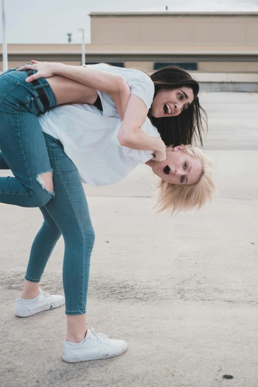 a couple of women standing on top of each other, pexels contest winner, happening, wearing pants and a t-shirt, kailee mandel, on the ground, bleached