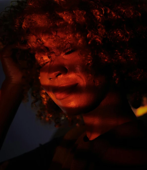 a close up of a person with a cell phone, an album cover, pexels, afrofuturism, reddish lighting, her hair is on fire, obscured underexposed view, glowing people