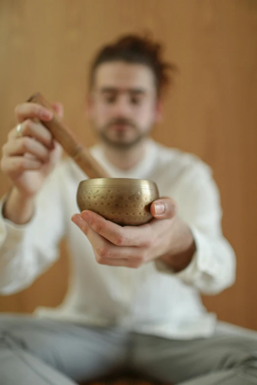 a man holding a singing bowl in his hands, an album cover, by Matthias Stom, unsplash, kinetic art, 15081959 21121991 01012000 4k, white, handcrafted, instagram picture