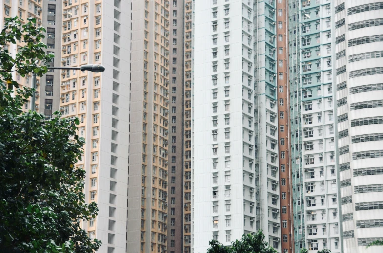 a group of tall buildings sitting next to each other, unsplash, hyperrealism, chungking express color palette, concrete housing, 2000s photo