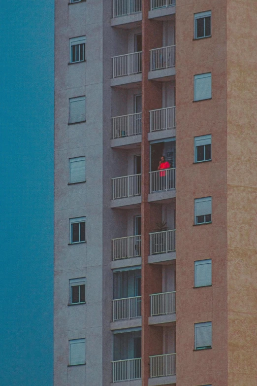 a couple of tall buildings sitting next to each other, an album cover, inspired by Elsa Bleda, unsplash contest winner, blue and red two - tone, tiny person watching, !!! colored photography, balconies