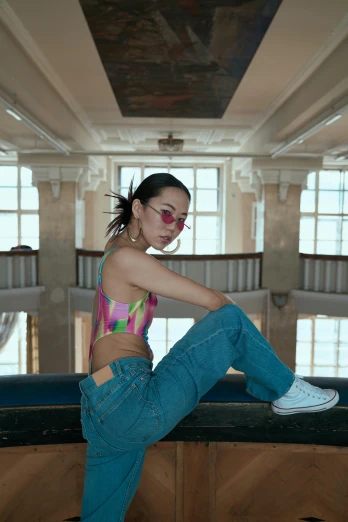 a woman sitting on top of a counter next to a window, an album cover, inspired by Fei Danxu, trending on pexels, raver girl, wearing jeans, bella poarch, official music video