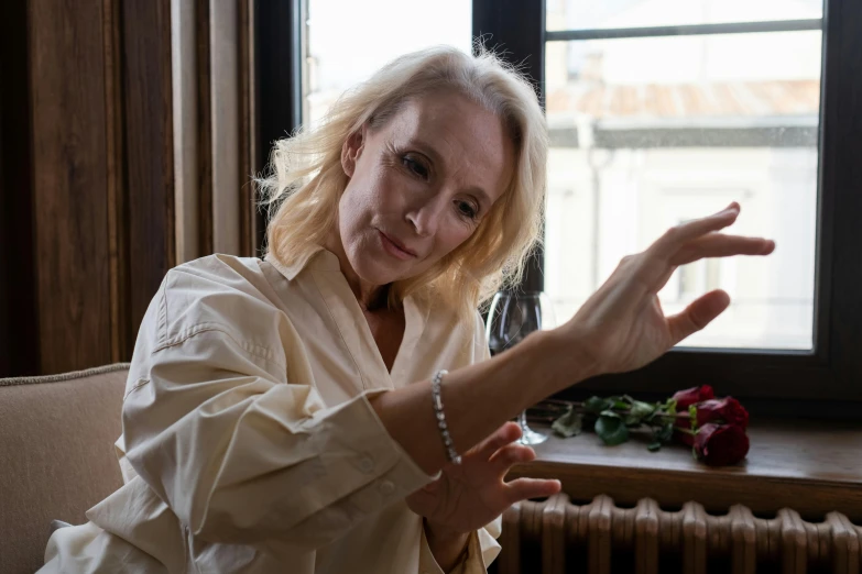 a woman sitting on a couch in front of a window, a portrait, inspired by Florence Engelbach, unsplash, photorealism, hands reaching for her, evanna lynch, uma thurman, doing an elegant pose over you