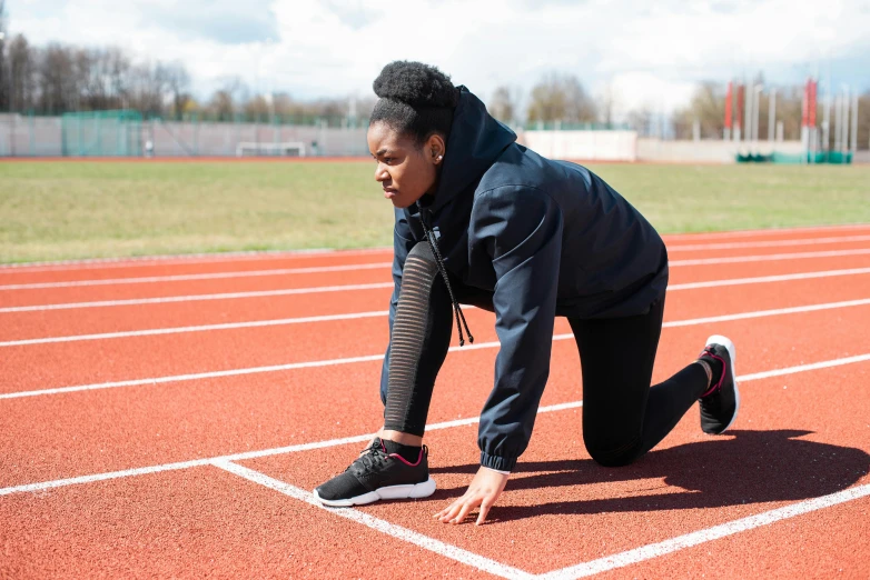 a woman getting ready to run on a track, pexels contest winner, essence, thumbnail, working out in the field, schools