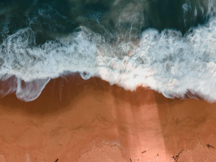 a person riding a surfboard on top of a sandy beach, pexels contest winner, minimalism, flowing salmon-colored silk, makes the sea area glowing water, satellite imagery, blue crashing waves