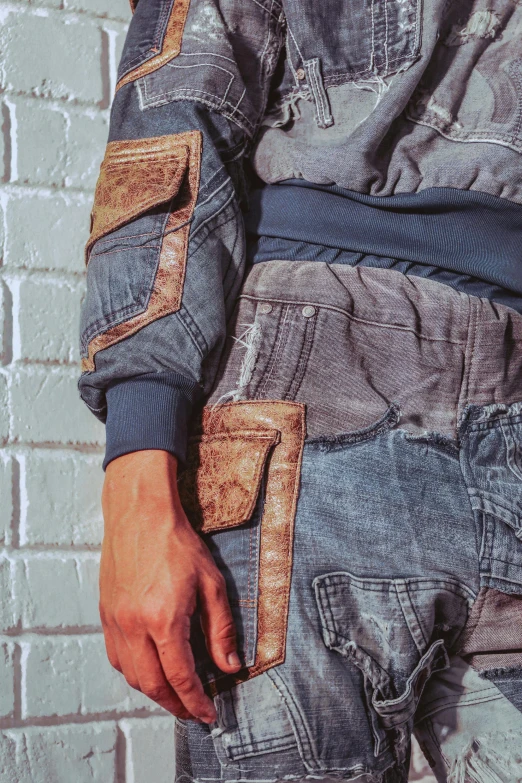 a man standing in front of a brick wall, inspired by Raphaël Collin, trending on unsplash, wearing dirty overalls, sci - fi details, mixed materials, zoomed in
