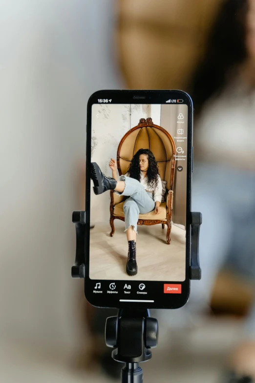 a cell phone sitting on top of a tripod, trending on pexels, renaissance, sitting on designer chair, fashion model features, zoomed out full body, tiktok video