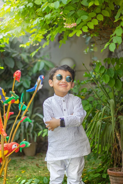 a little boy that is standing in the grass, by Riza Abbasi, wearing shades, in garden, multi chromatic, having a cool party