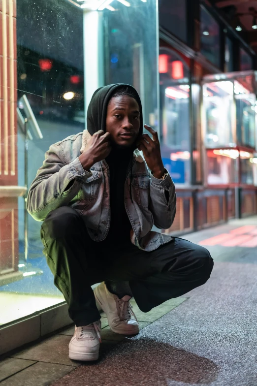 a man sitting on the ground talking on a cell phone, trending on pexels, realism, : kendrick lamar, man standing in defensive pose, night outside, handsome hip hop young black man