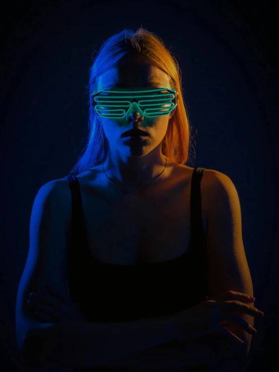 a woman wearing neon glasses in the dark, inspired by Elsa Bleda, reddit, dimensional cyan gold led light, high quality photo, portrait of kim petras, sleek oled blue visor for eyes