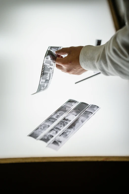 a close up of a person holding a piece of paper, a photocopy, unsplash, video art, 1981 photograph, contact sheet, high quality photo, studio photo