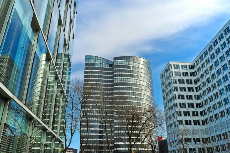 a couple of buildings that are next to each other, a photo, pexels contest winner, bauhaus, glass and metal : : peugot onyx, circular towers, three towers, buildings photorealism