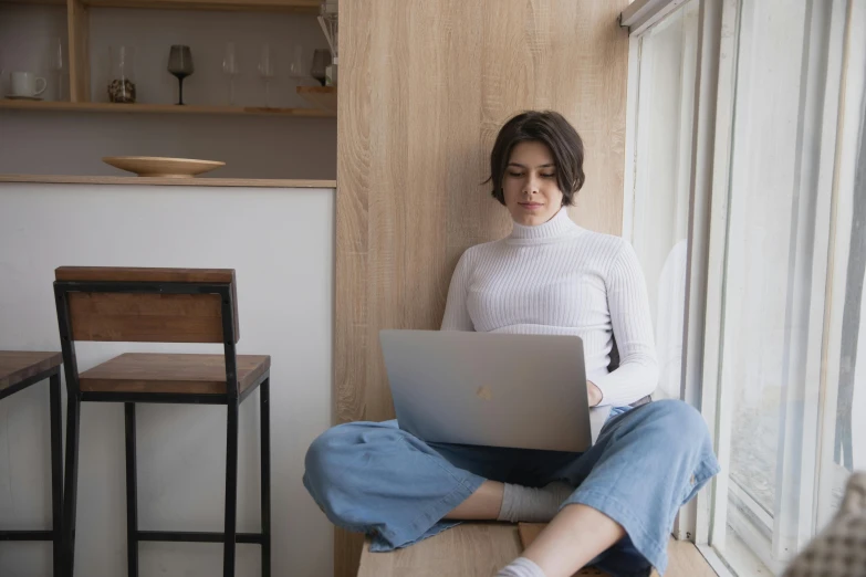 a woman sitting on a window sill using a laptop, a portrait, by Carey Morris, trending on pexels, renaissance, sitting on bent knees, avatar image, caucasian, sitting on a store shelf