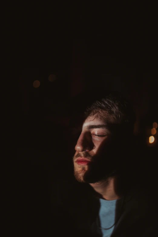 a man with his eyes closed in the dark, a picture, light and space, liam brazier, low quality photo, dof and bokeh, max dennison