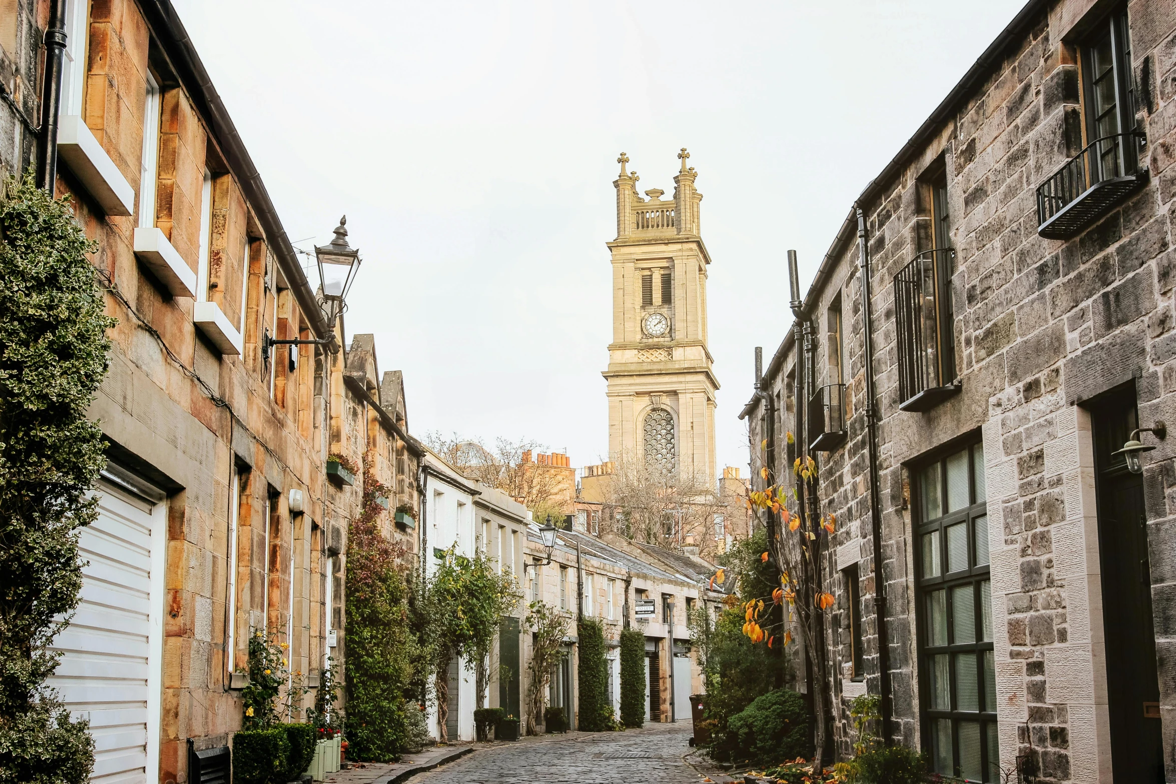 a cobblestone street with a clock tower in the background, by Gawen Hamilton, pexels contest winner, whitewashed buildings, jen atkin, scottish style, conde nast traveler photo