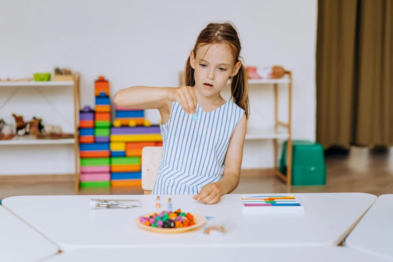 a little girl sitting at a table with a birthday cake, a child's drawing, pexels contest winner, 3 d clay figure, children playing with pogs, fragile girl holding an arrow, product introduction photo