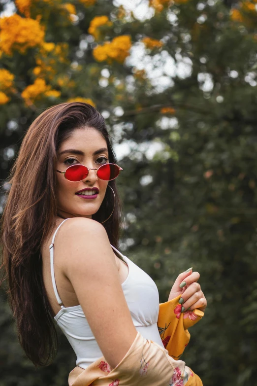 a woman that is standing in the grass, trending on pexels, red sunglasses, lorde, gold and red metal, round-cropped