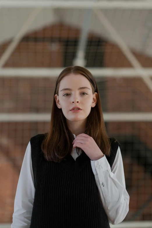 a woman in a black vest and white shirt, inspired by Anna Füssli, trending on unsplash, dressed as schoolgirl, mackenzie foy, ignant, smooth in _ the background