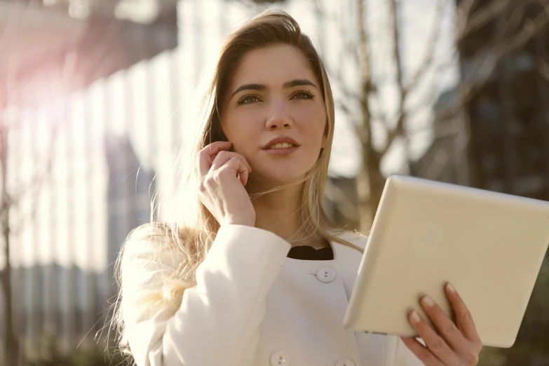 a woman talking on a cell phone while holding a tablet, trending on pexels, a girl with blonde hair, professional image, sunlit, elegant face