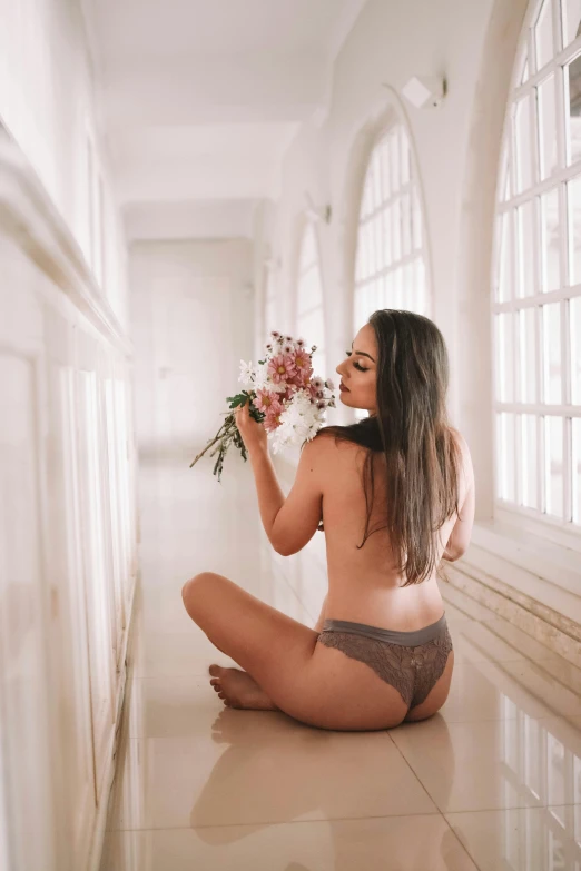 a woman sitting on the floor holding a bunch of flowers, unsplash, lace underwear, brazil, back arched, 5 0 0 px models