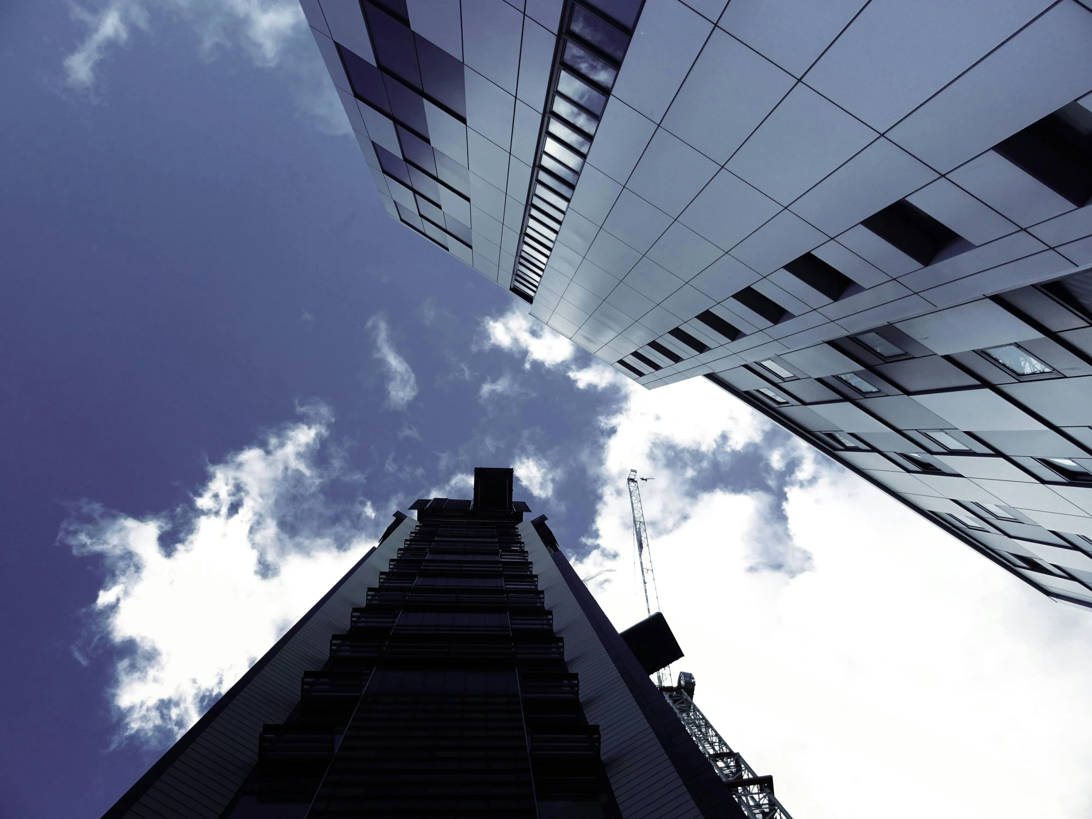 a couple of tall buildings sitting next to each other, inspired by Richard Wilson, unsplash, looking up onto the sky, three views, ignant, music video