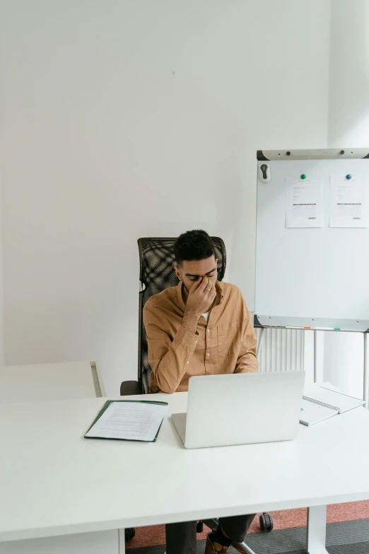 a man sitting at a desk with a laptop in front of him, pexels contest winner, embarrassed, minimalist environment, face covered, reddit post