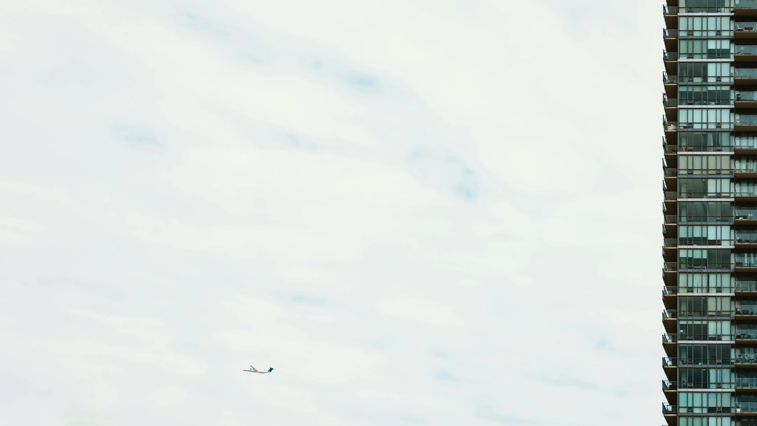 a plane flying in front of a tall building, by Carey Morris, unsplash, minimalism, white, heavens, fan favorite, rinko kawauchi