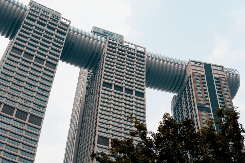 a couple of tall buildings sitting next to each other, inspired by Victor Enrich, pexels contest winner, sky bridges, massive arch, set on singaporean aesthetic, giant tentacles