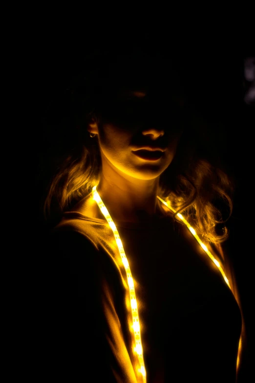 a woman that is standing in the dark, golden ratio jewelry lights, led light strips, amber glow, close up half body shot