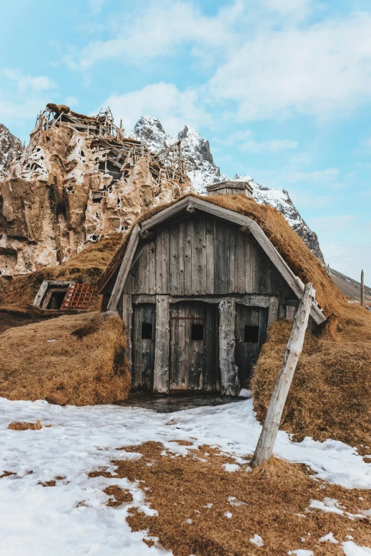 a barn in the snow with a mountain in the background, a picture, unsplash contest winner, renaissance, empty bathhouse hidden in a cave, remote icelandic village, wooden toilets, tiny house