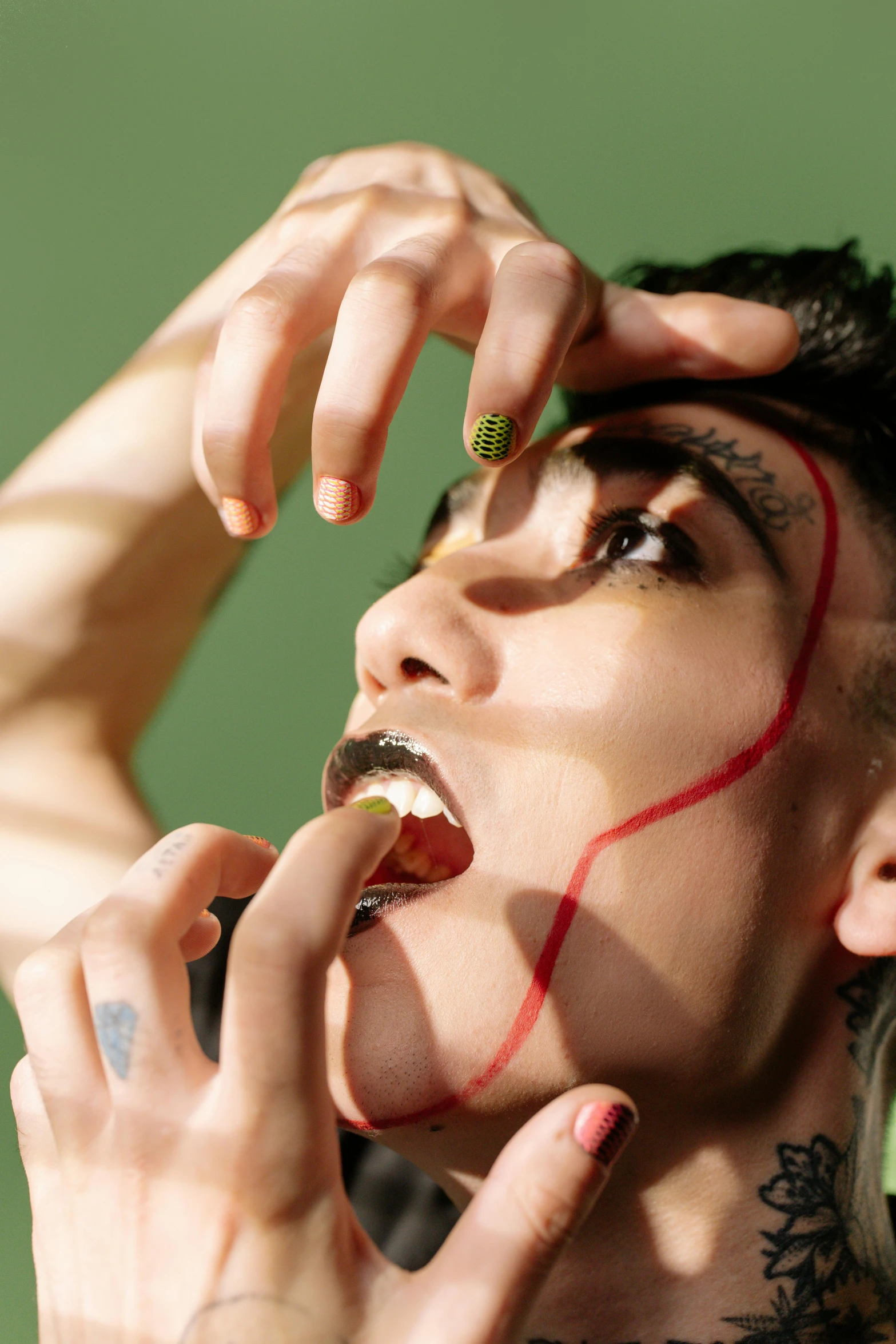 a close up of a person with tattoos on their face, an album cover, inspired by Ren Hang, <pointé pose>;open mouth, robert sheehan, having a snack, an epic non - binary model