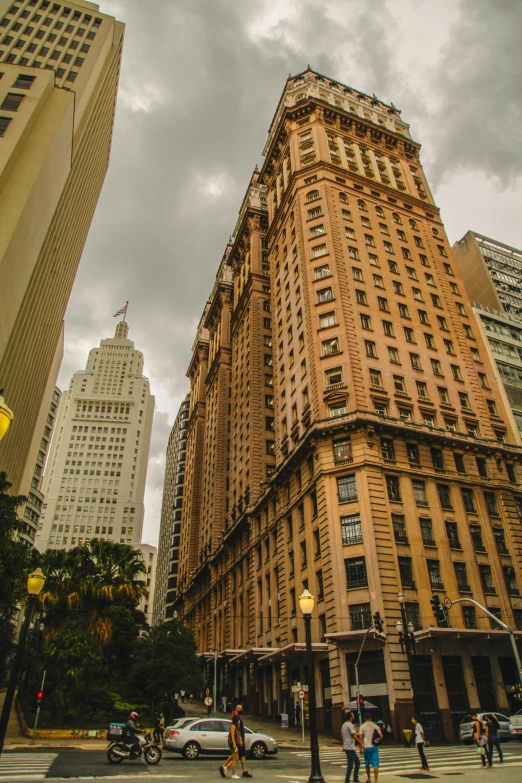 a group of people walking across a street next to tall buildings, stunning grand architecture, louisiana, perched on a skyscraper, phot