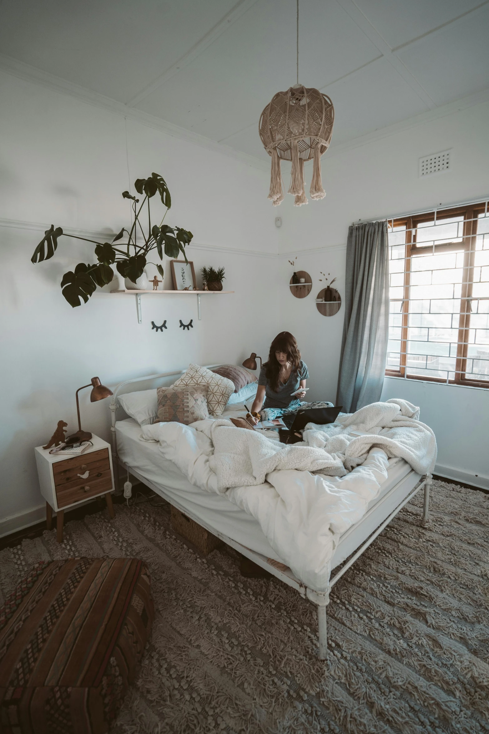 a woman sitting on a bed reading a book, inspired by Elsa Bleda, unsplash contest winner, decoration around the room, low quality photo, wide full body, snapchat photo