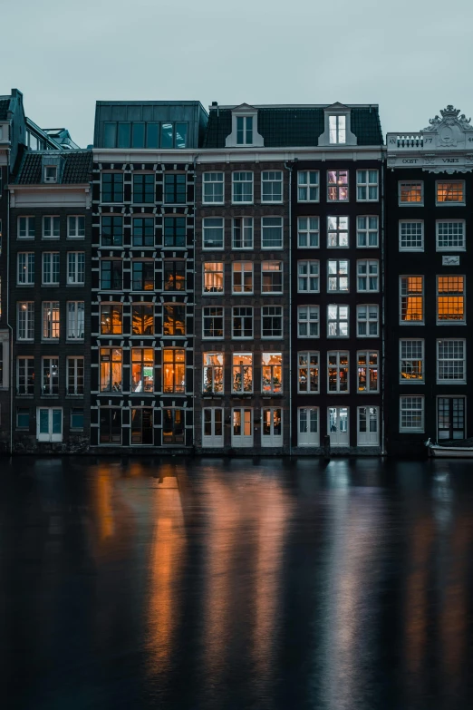 a row of buildings next to a body of water, by Jan Tengnagel, pexels contest winner, neoclassicism, vermeer lighting, black windows, portrait shot, detailed photo 8 k