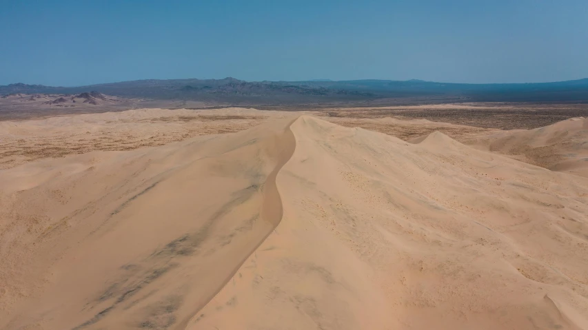 a dirt road in the middle of a desert, pexels contest winner, land art, soft-sanded coastlines, profile image, aerial footage, dune