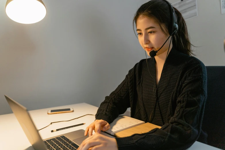 a woman wearing a headset working on a laptop, inspired by Ruth Jên, trending on pexels, hurufiyya, kramskoi 4 k, asian girl, background image