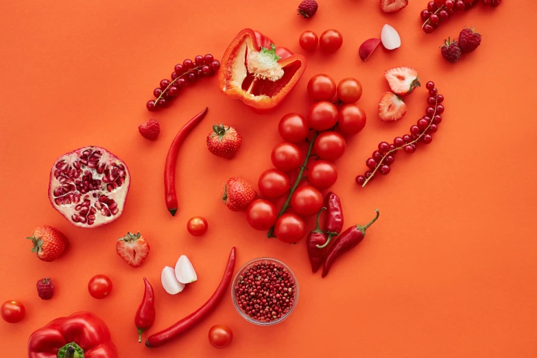 a variety of fruits and vegetables on an orange background, trending on pexels, in crimson red, red adornments, background image, spicy