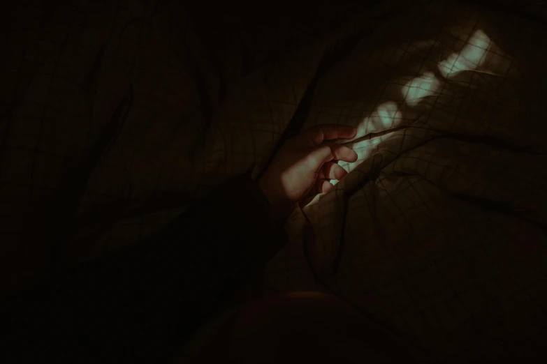 a person laying in bed under a blanket, inspired by Elsa Bleda, trending on pexels, australian tonalism, holding hands in the moonlight, low quality photo, dark image, luminous veins