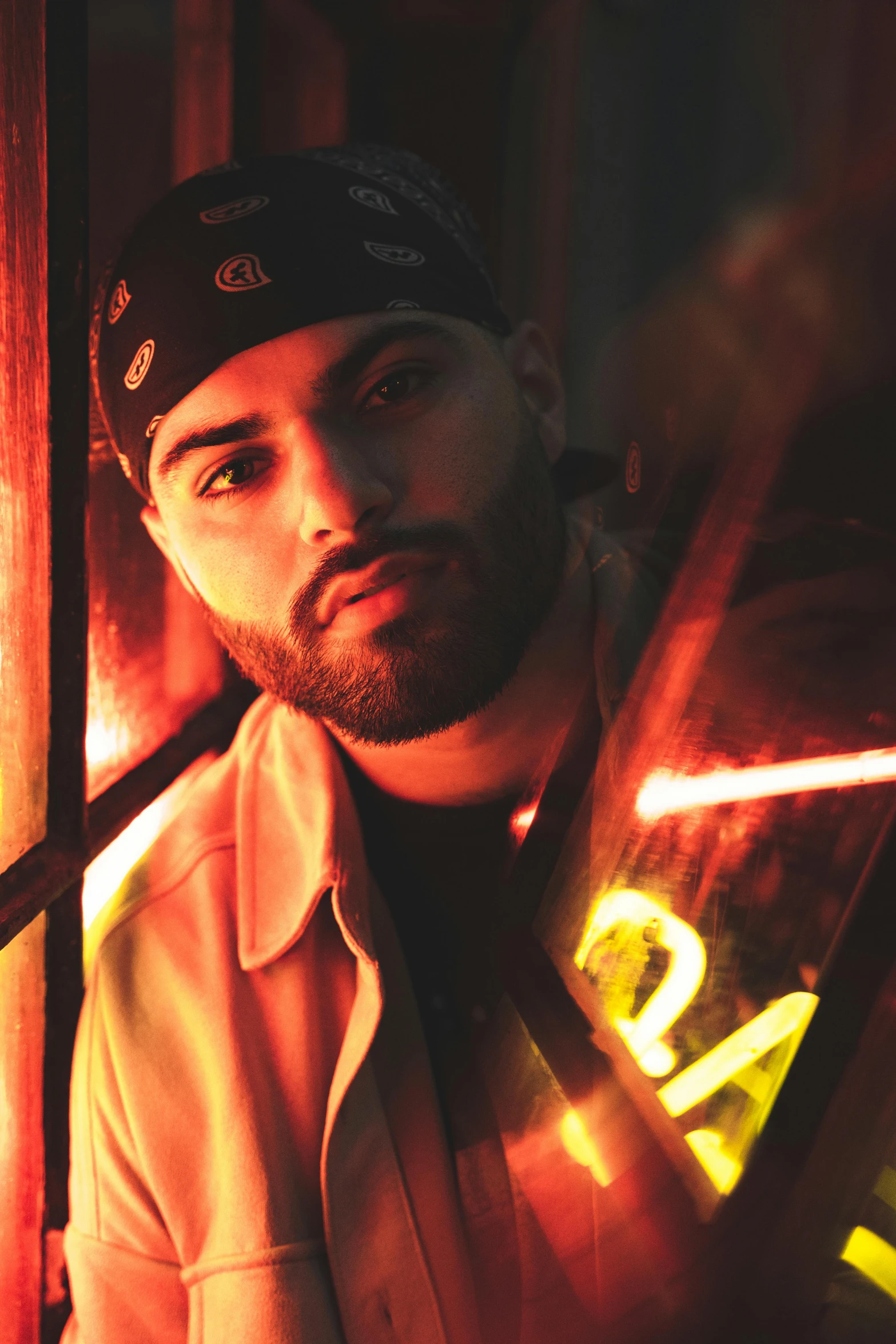 a man holding a baseball bat next to a window, an album cover, by Robbie Trevino, lyco art, high red lights, arab man light beard, looking to camera, wearing a bandana and chain