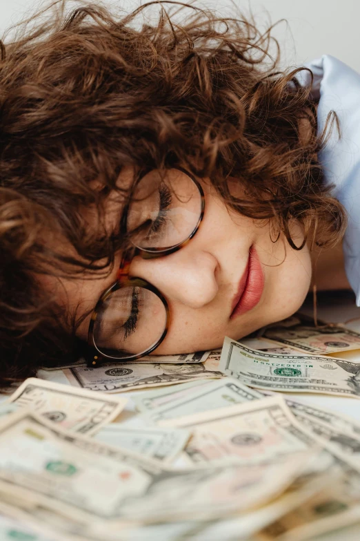 a woman sleeping on top of a pile of money, trending on pexels, curly bangs, girl wearing round glasses, teenage boy, thumbnail