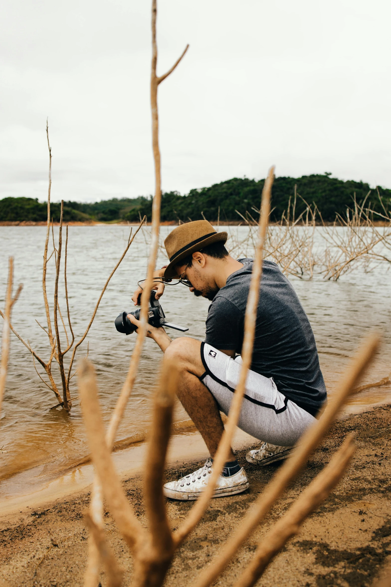 a man taking a picture of a body of water, looking at the camera, on a riverbank, 2019 trending photo, outdoor photo